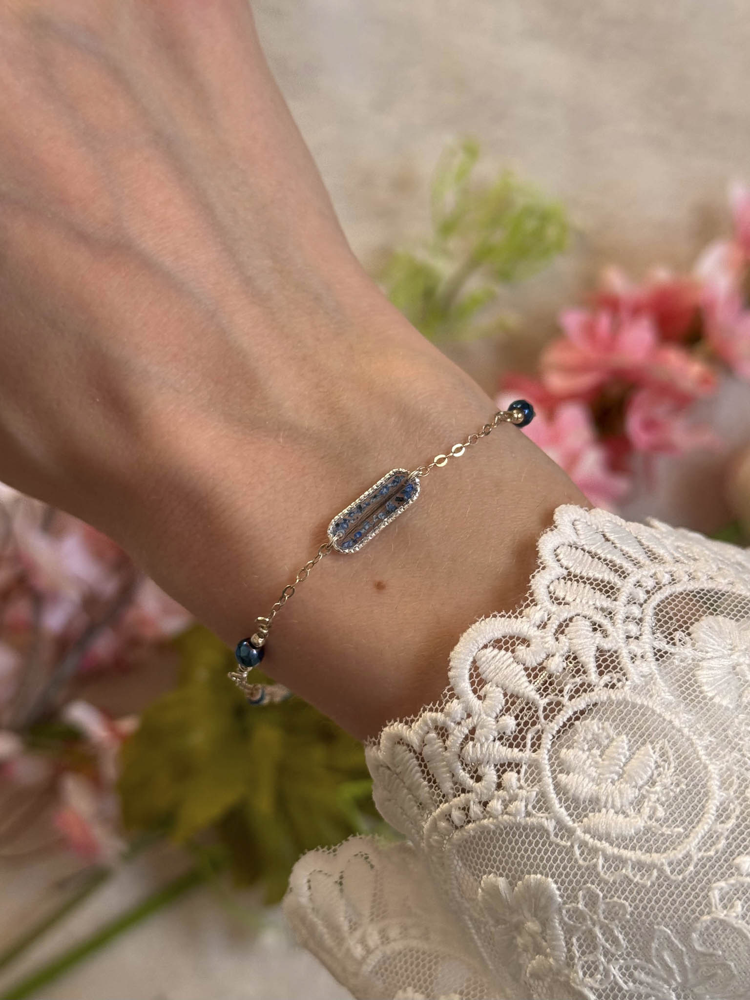 Bracelet Harmonie au poignet, breloque rectangulaire bleue et perles bleu foncé.
