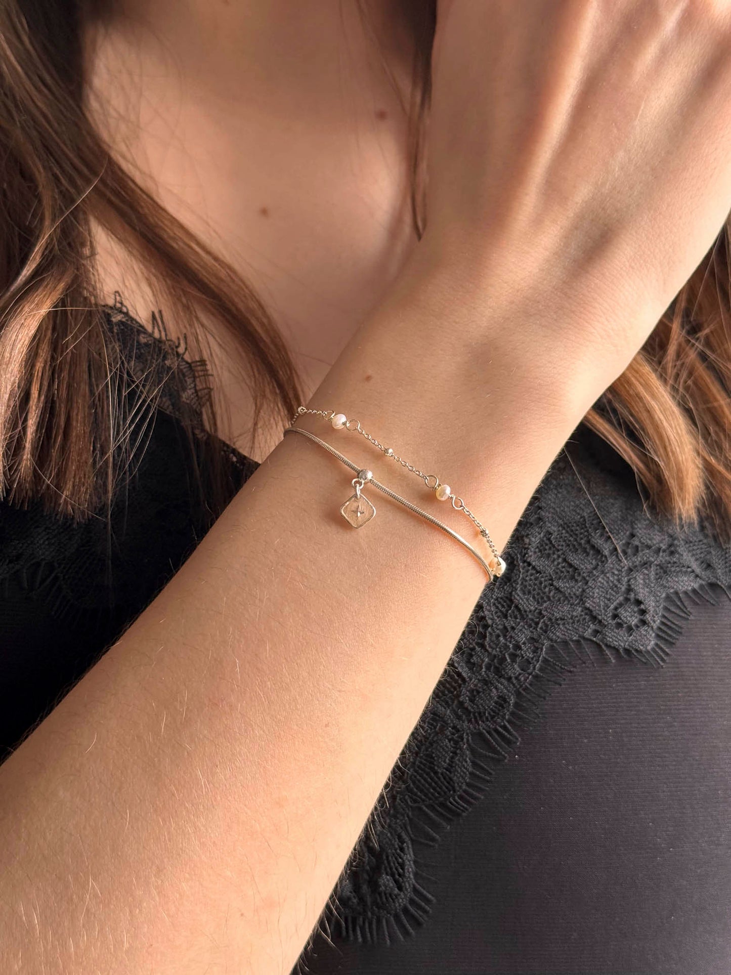 Bracelet fin avec perles blanches et petit pendentif en forme de losange