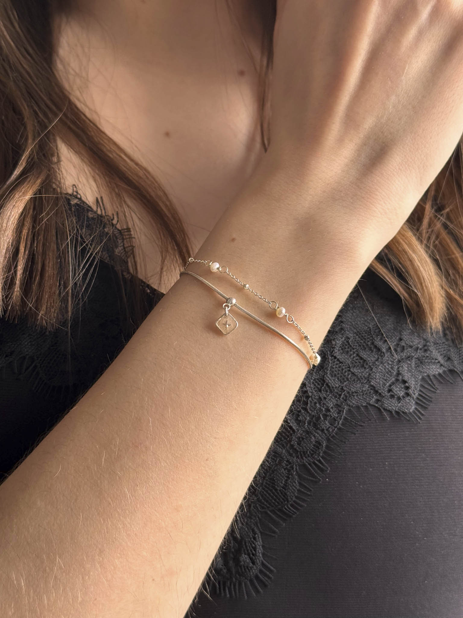 Bracelet fin avec perles blanches et petit pendentif en forme de losange