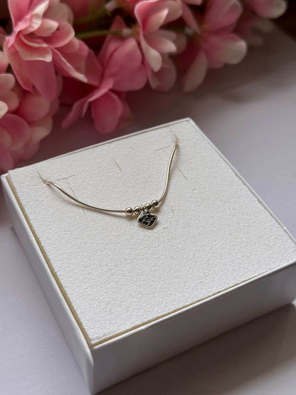 Collier doré : pendentif noir en forme de petit carré et chaîne fine