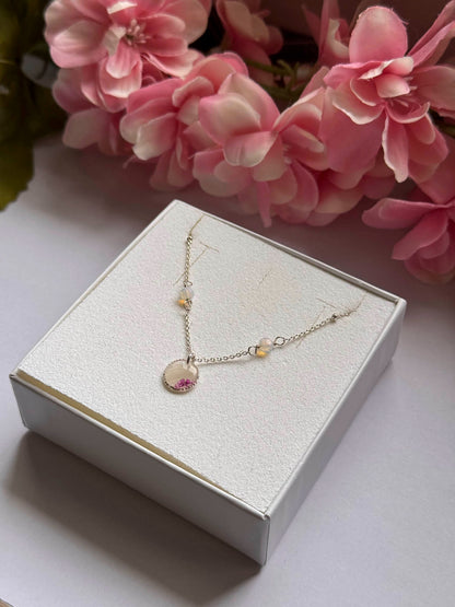Collier Éclipse sur boîte : chaîne dorée et pendentif rond rose, petites perles