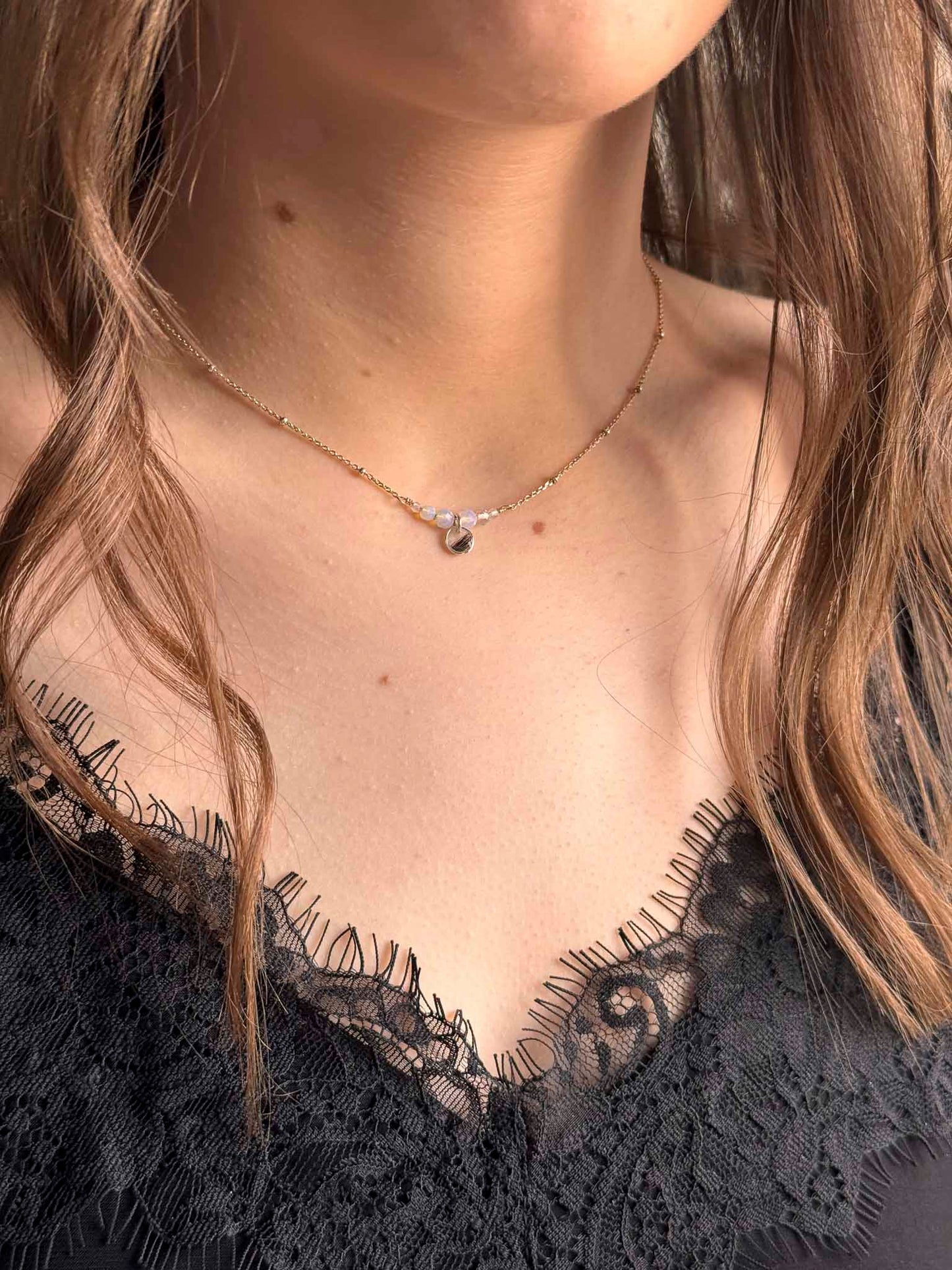 Collier Opale au pendentif goutte, chaîne fine avec petites pierres brillantes.