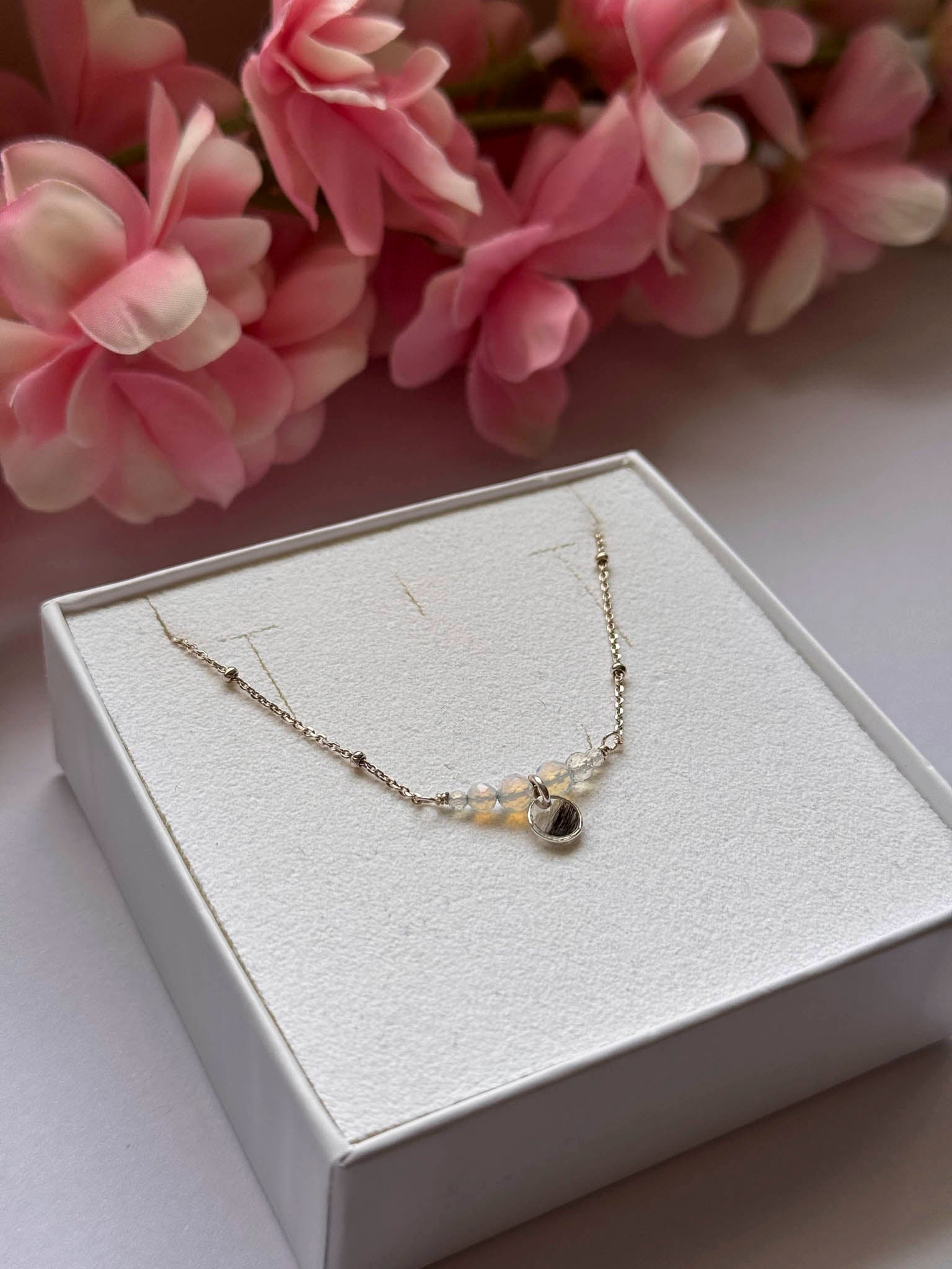 Collier Opale avec pendentif goutte et perles claires sur la chaînette.