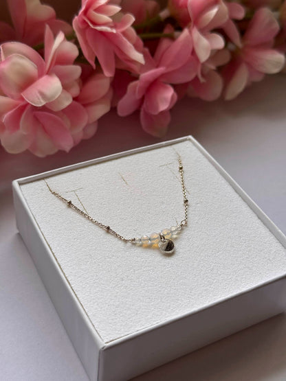 Collier Opale avec pendentif goutte et perles claires sur la chaînette.