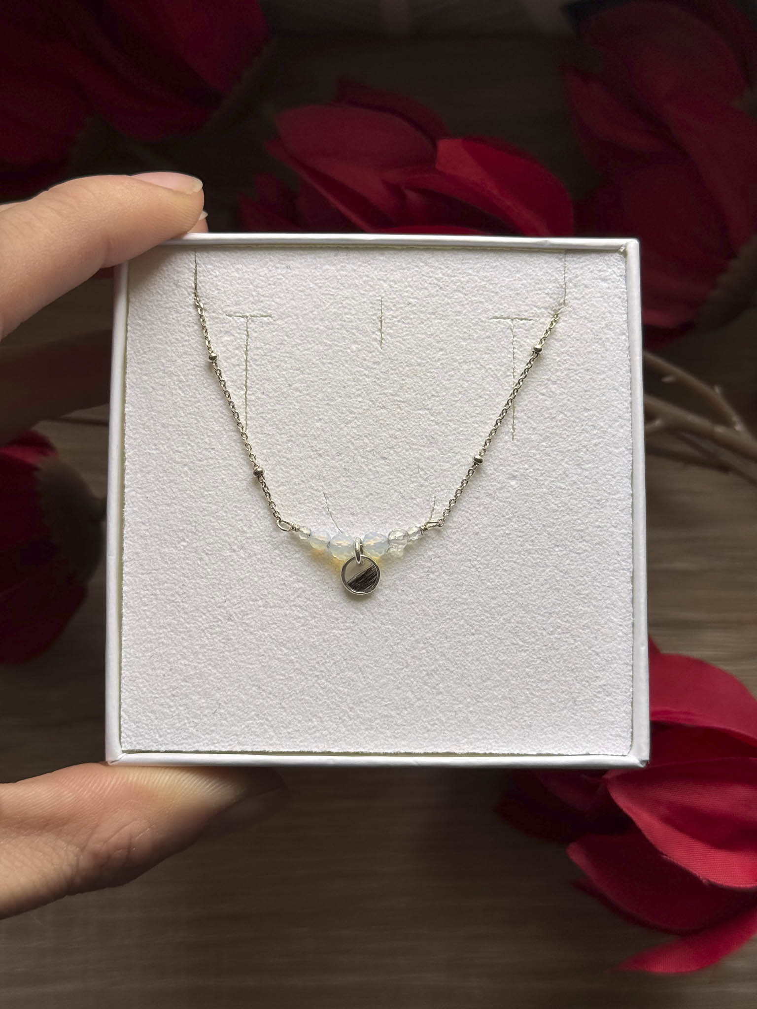Collier Opale en boîte, chaîne fine et pendentif en forme de goutte.