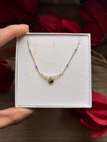 Collier Opale en boîte, chaîne fine et pendentif en forme de goutte.